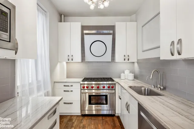 a kitchen with white cabinets and refrigerator