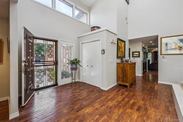 a view of a hallway with wooden floor and a living room