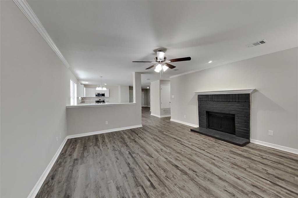 2005 Fairview Drive Forney, TX 75126 - Photo 2 of 18 a view of a kitchen and an empty room with wooden floor and a fireplace