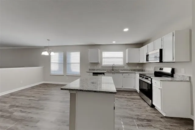 a kitchen with granite countertop white cabinets and white appliances
