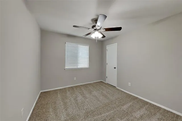 a view of an empty room with a ceiling fan