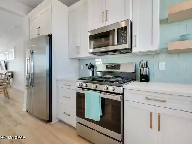 a kitchen with white cabinets and a sink