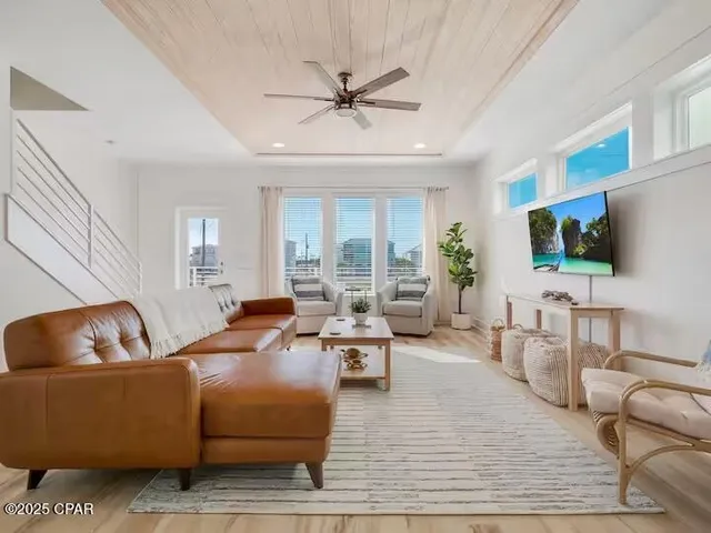 a living room with furniture flat screen tv and a large window