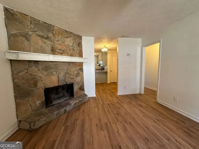 a view of a livingroom with wooden floor and a fireplace