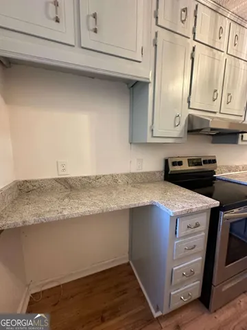a kitchen with stainless steel appliances granite countertop a sink a stove and cabinets