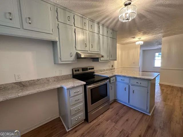 a kitchen with stainless steel appliances granite countertop a stove a sink and a refrigerator