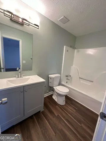 a bathroom with a sink mirror vanity and toilet