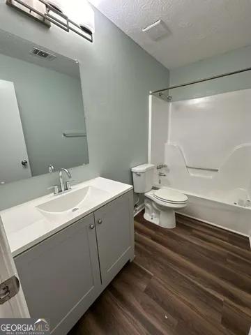 a bathroom with a sink toilet a mirror and shower