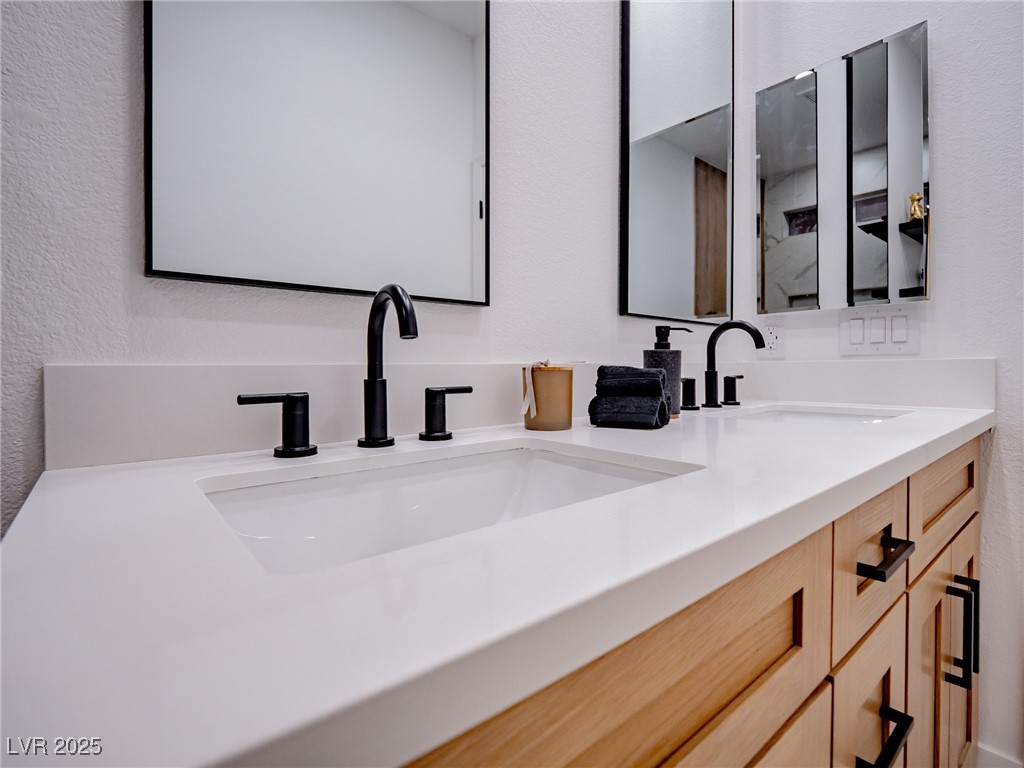 7870 Midnight Ride Street Las Vegas, NV 89131 - Photo 33 of 69 Full bathroom featuring a textured wall and double vanity