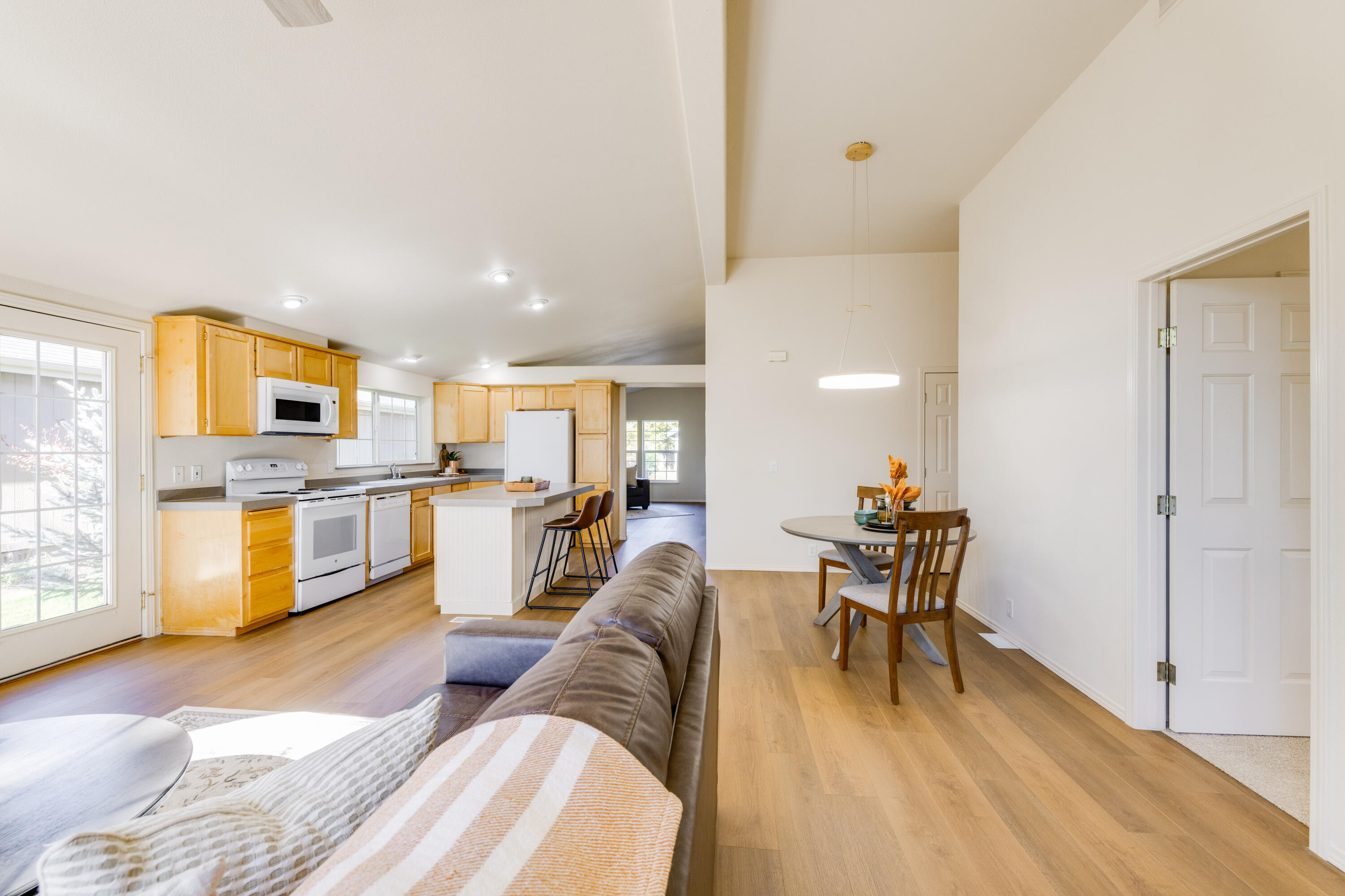 278 North Wheeler Loop Sisters, OR 97759 - Photo 9 of 22 a living room with couches and kitchen view with wooden floor