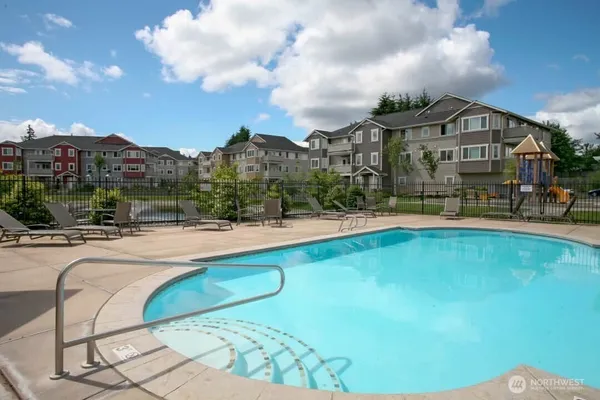 a view of a house with swimming pool and sitting area