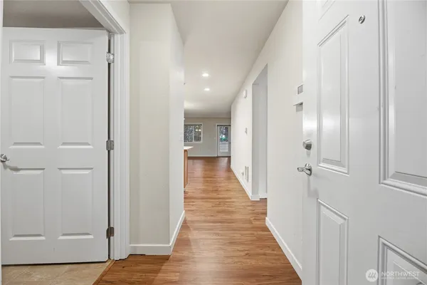 a view of a hallway with wooden floor and staircase