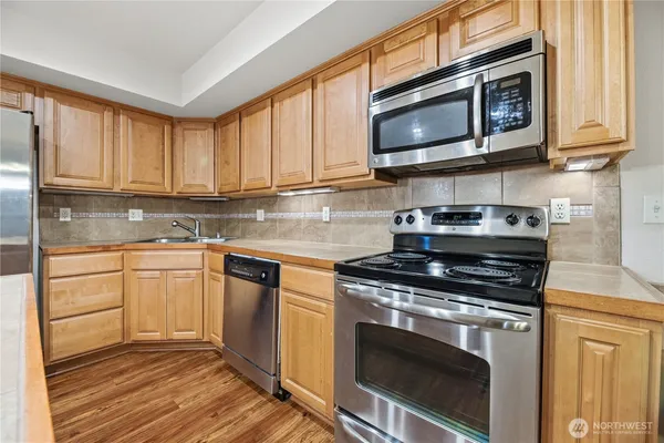 a kitchen with stainless steel appliances granite countertop a stove microwave and cabinets