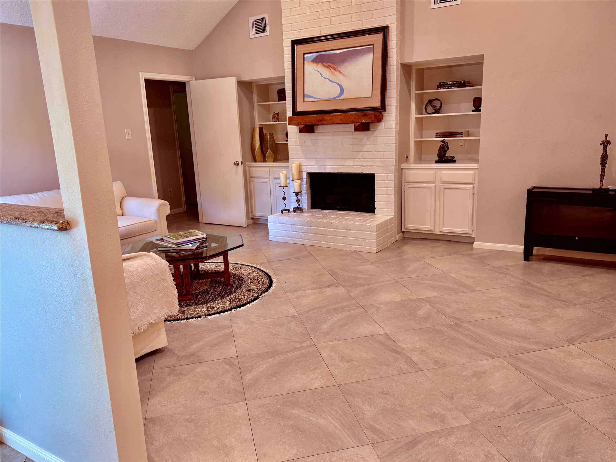 13 Maywind Court The Woodlands, TX 77381 - Photo 9 of 33 Spacious family room features a floor-to-ceiling brick fireplace, built-ins & new 2026 recessed lighting.