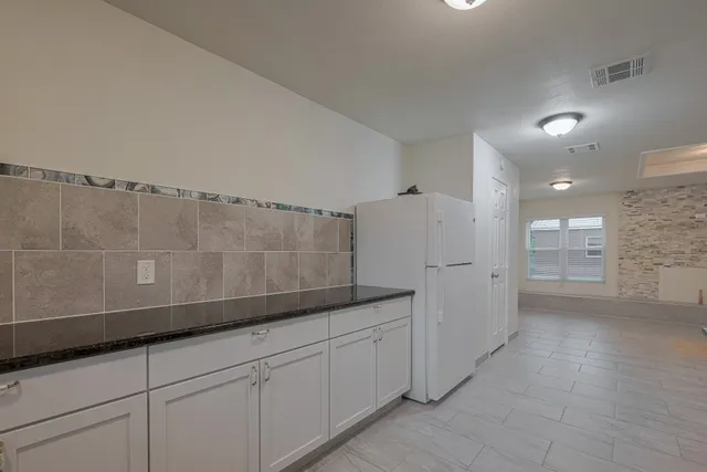 a view of a kitchen with white cabinets