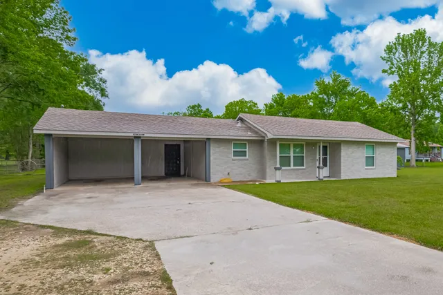 a front view of a house with a garden and yard