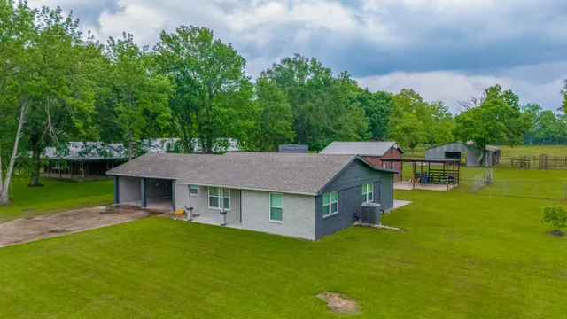a aerial view of a house with a yard table and chairs