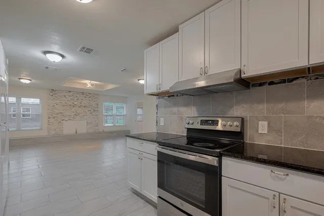 a kitchen with granite countertop a stove and a sink