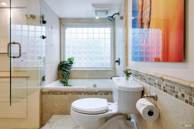 a bathroom with a granite countertop toilet sink and mirror
