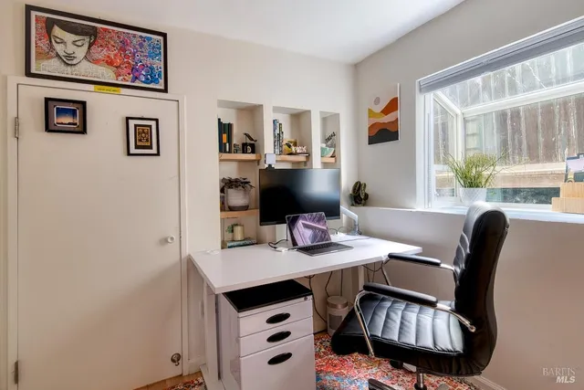 a view of a workspace with furniture and a potted plant