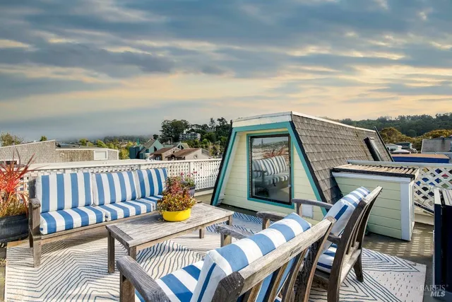 a view of a chairs and table on the roof deck