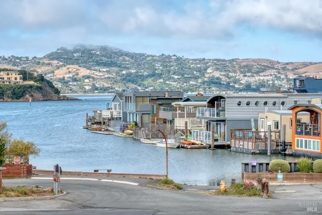 an aerial view of residential houses with outdoor space and parking