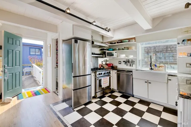 a kitchen with granite countertop stainless steel appliances a sink and a counter top space