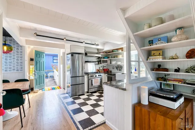 a kitchen with stainless steel appliances kitchen island granite countertop a refrigerator and a stove top oven
