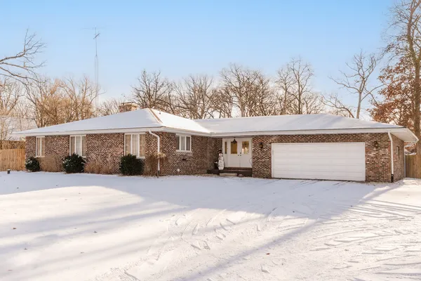 a front view of a house with a yard covered in snow