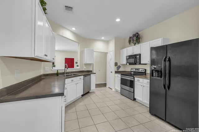 a kitchen with a sink a counter top space stainless steel appliances and cabinets