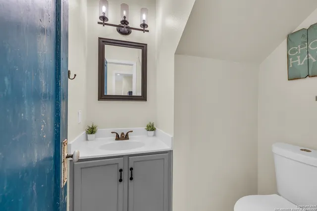 a bathroom with a toilet sink and mirror