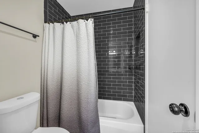a bathroom with a shower curtain and toilet