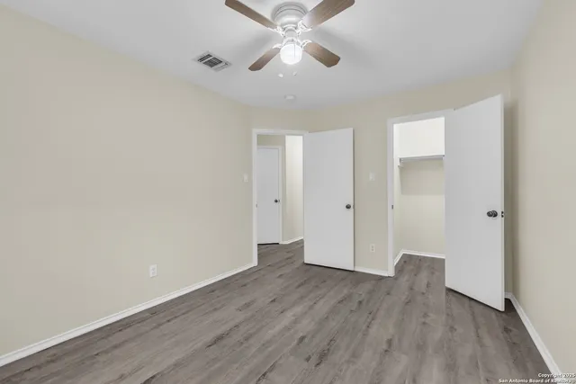 wooden floor in an empty room with a fan