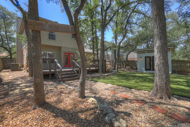 a view of a house with a yard tree and a large tree