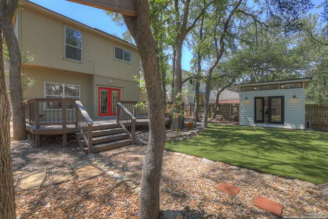 a view of a house with backyard and a tree