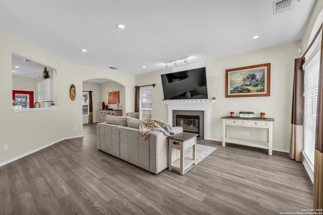 a living room with furniture a fireplace and a flat screen tv