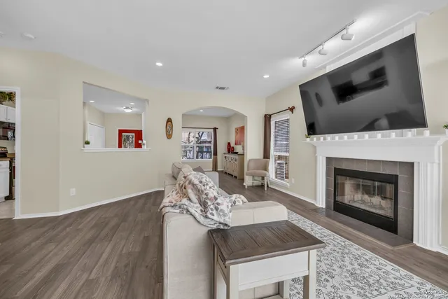 a living room with furniture a flat screen tv and a fireplace