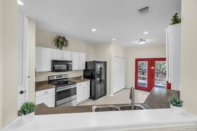 a kitchen with stainless steel appliances granite countertop a refrigerator and a stove top oven