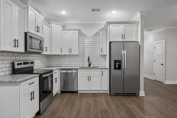 a kitchen with stainless steel appliances a refrigerator sink and microwave