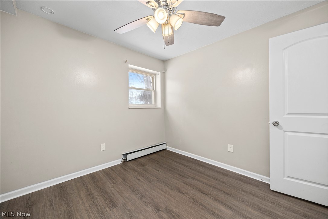 5382 Lee Road, Unit 102 Maple Heights, OH 44137 - Photo 25 of 25 Spare room with dark wood-type flooring, baseboard heating, and a ceiling fan