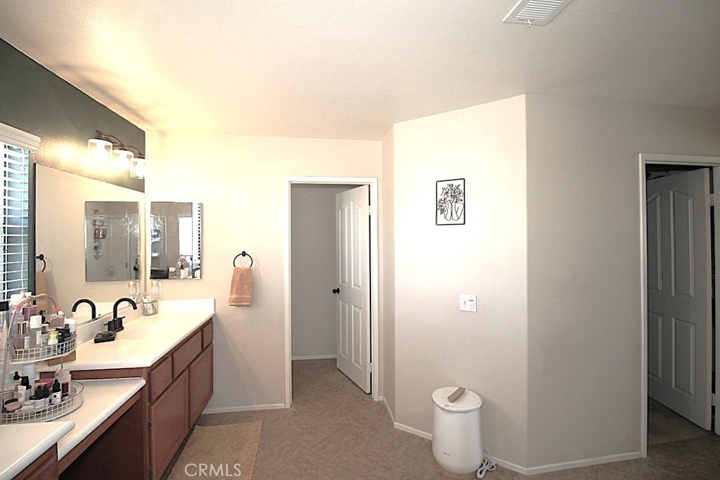 924 Condor Street Barstow, CA 92311 - Photo 40 of 52 a spacious bathroom with a double vanity sink a mirror and a toilet