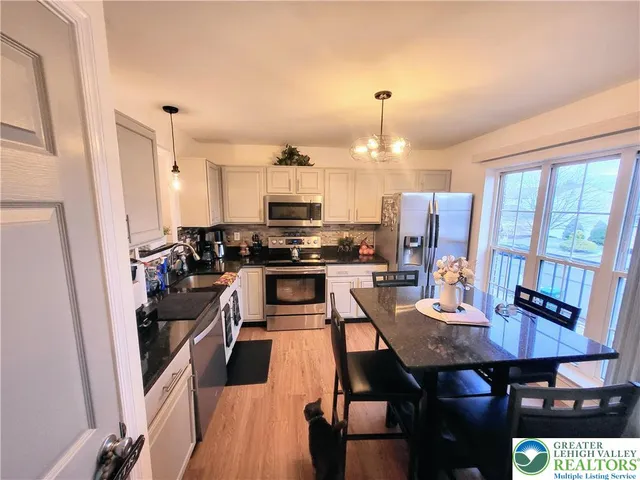 a kitchen with stainless steel appliances a dining table and chairs
