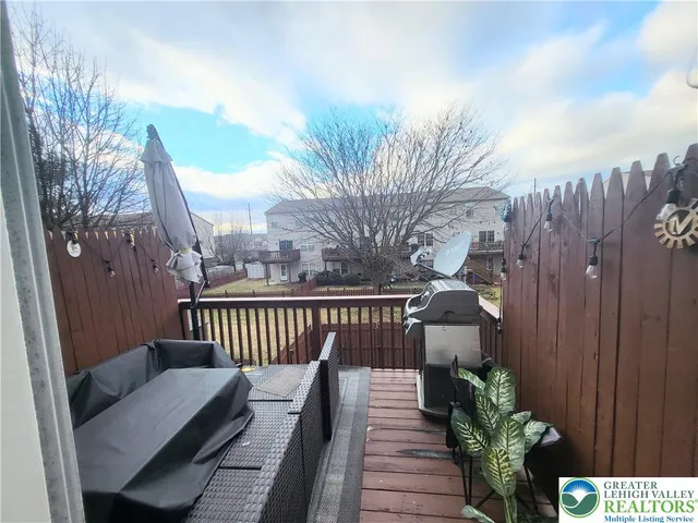 a balcony with wooden floor table and chairs