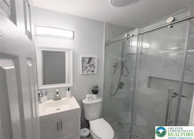 a bathroom with a granite countertop sink toilet and shower