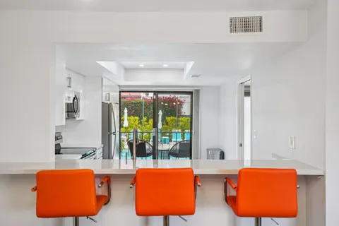 a living room with blue lights with furniture and garden view