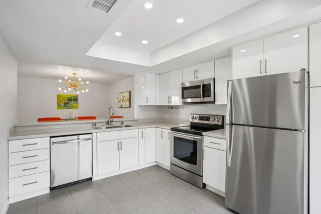 a kitchen with white cabinets and stainless steel appliances