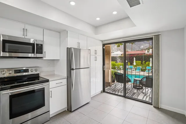 a kitchen with a refrigerator a stove top oven a sink and a window