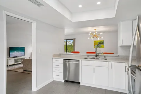 a kitchen with white cabinets and sink