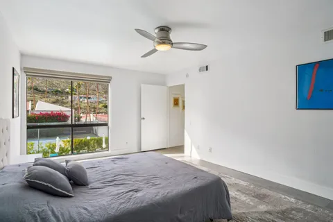 a bed sitting in a bedroom next to a window