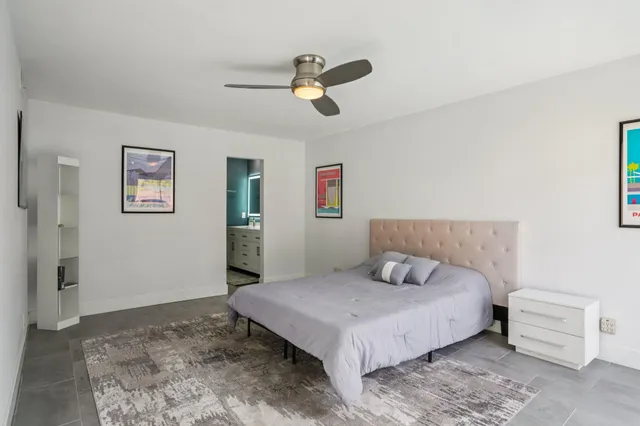 a bedroom with a large bed and ceiling fan